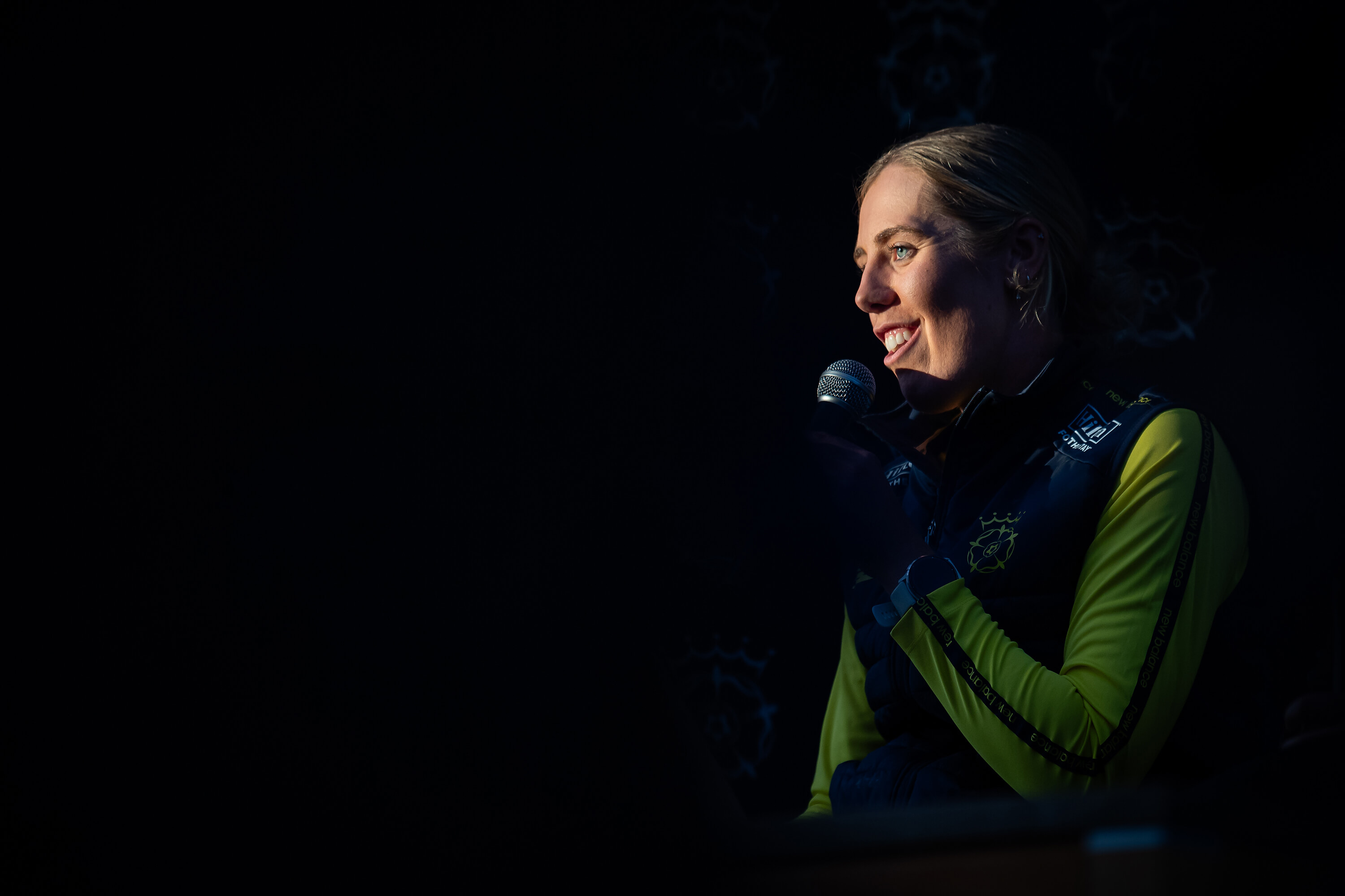 Georgia Adams speaking into a microphone at the women's season launch party