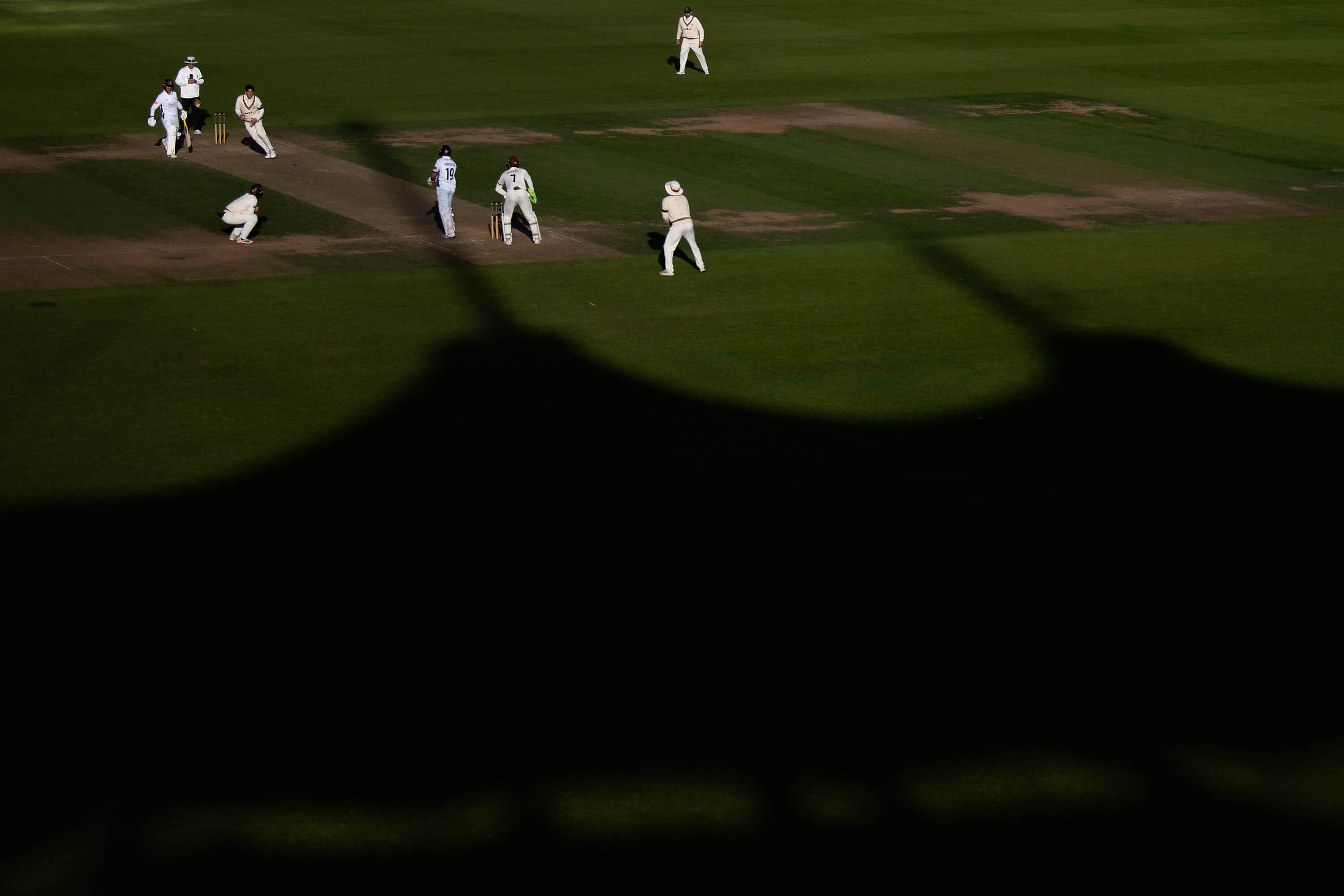 Shadows of the Rod Bransgrove Pavilion quilt the outfield of Utilita Bowl during Hampshire's County Championship match against Surrey